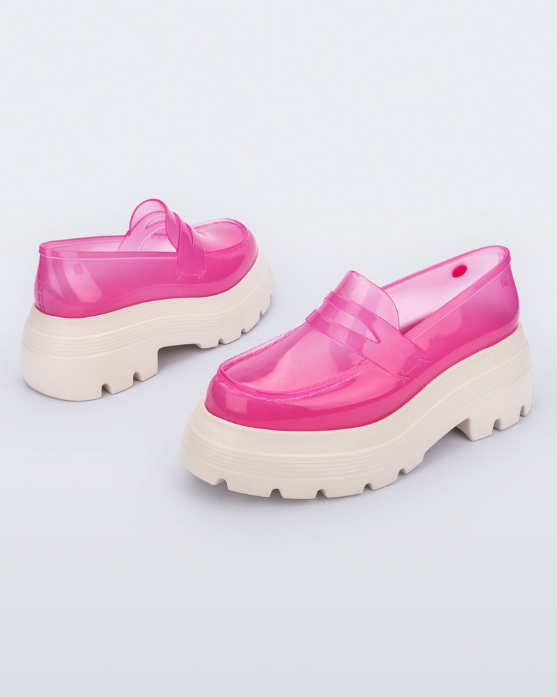 Angled view of a pair of transparent pink Royal High + Undercover platform loafers with beige sole.