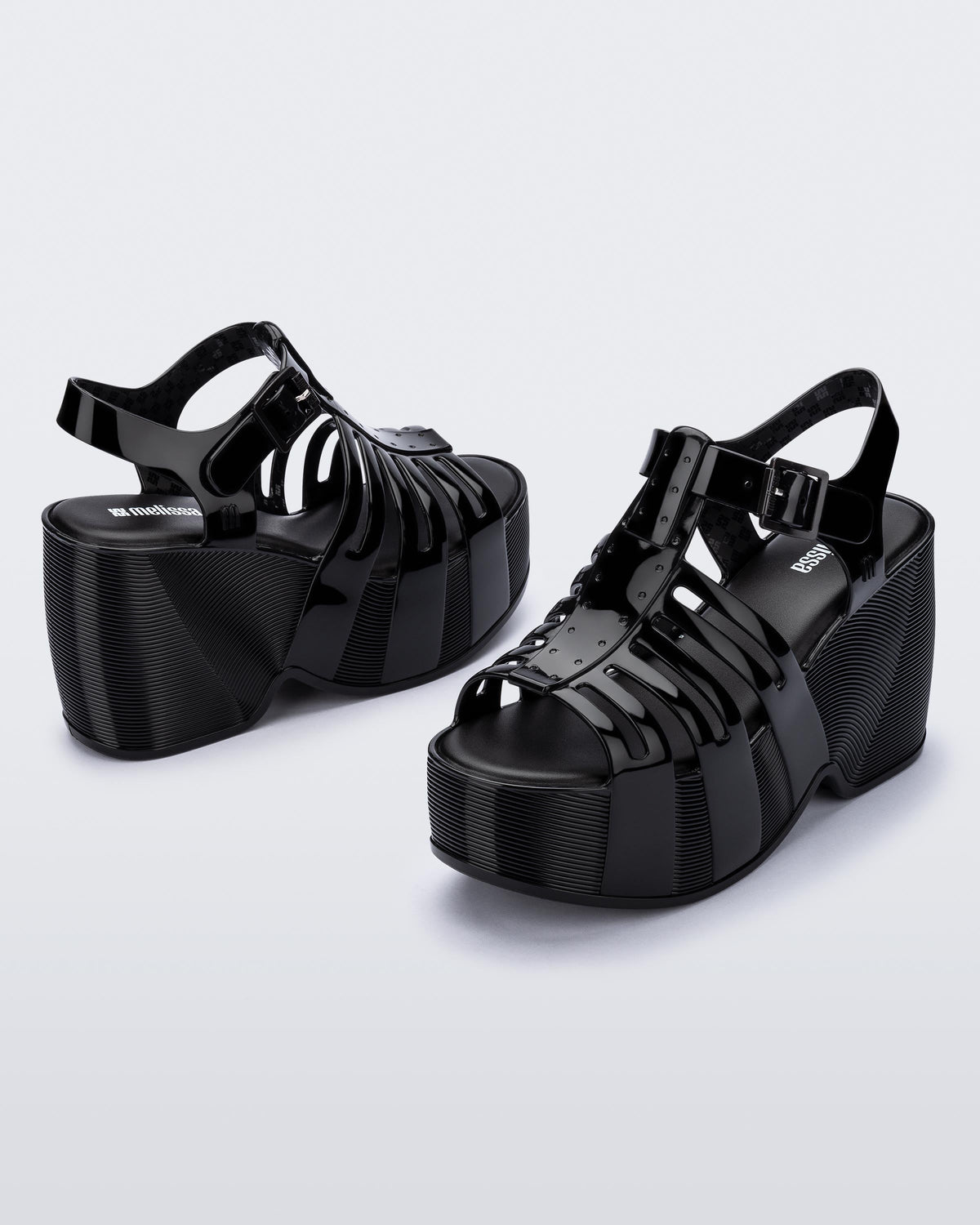 Back and side angled view of a pair of black Station 79 platform heels with ankle straps