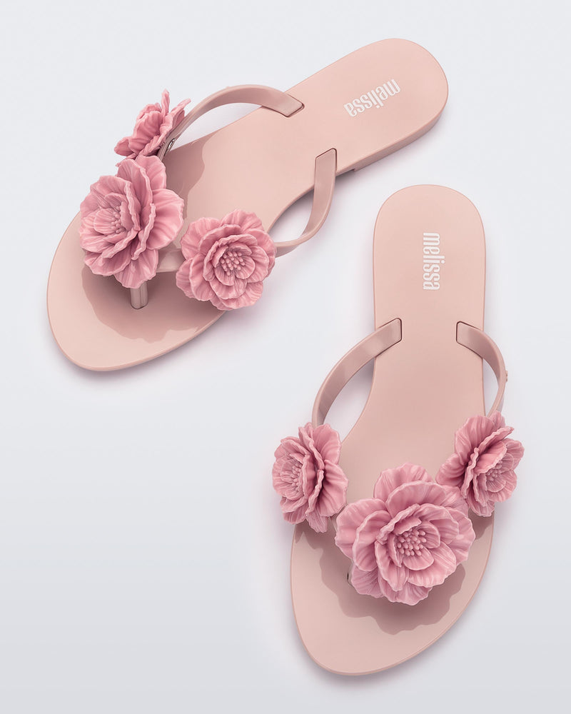 Top view of a pair of pink Harmonic Springtime women's flip flop with 3 pink flowers.