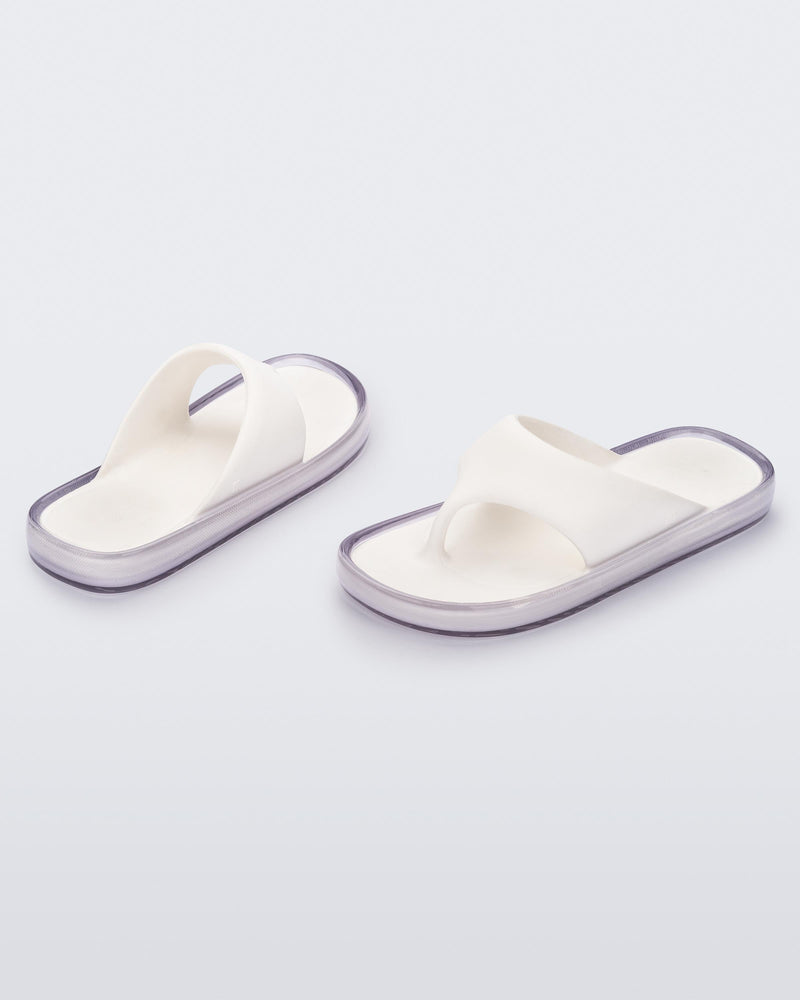 Angled view of a pair of white with clear sole Float flip flops
