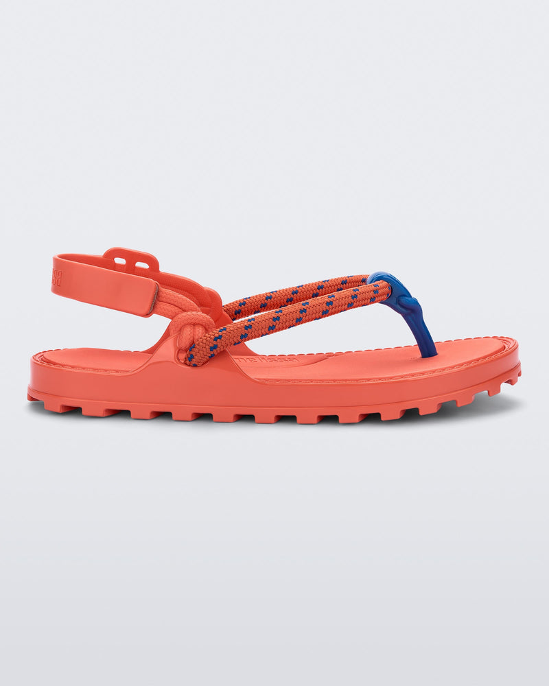 Side view of a orange Bond sandal with textile strap and blue toe piece