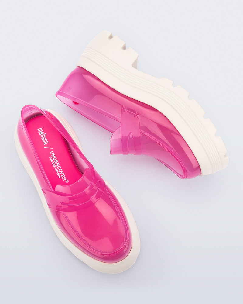Top and side view of a pair of transparent pink Royal High + Undercover platform loafers with beige sole.