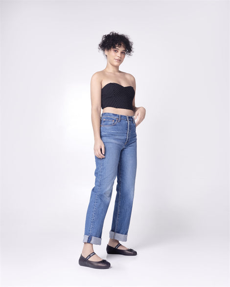 Model posing in jeans and a black top wearing a pair of Melissa Sophie ballet flats in black with M-logo strap and bow applique