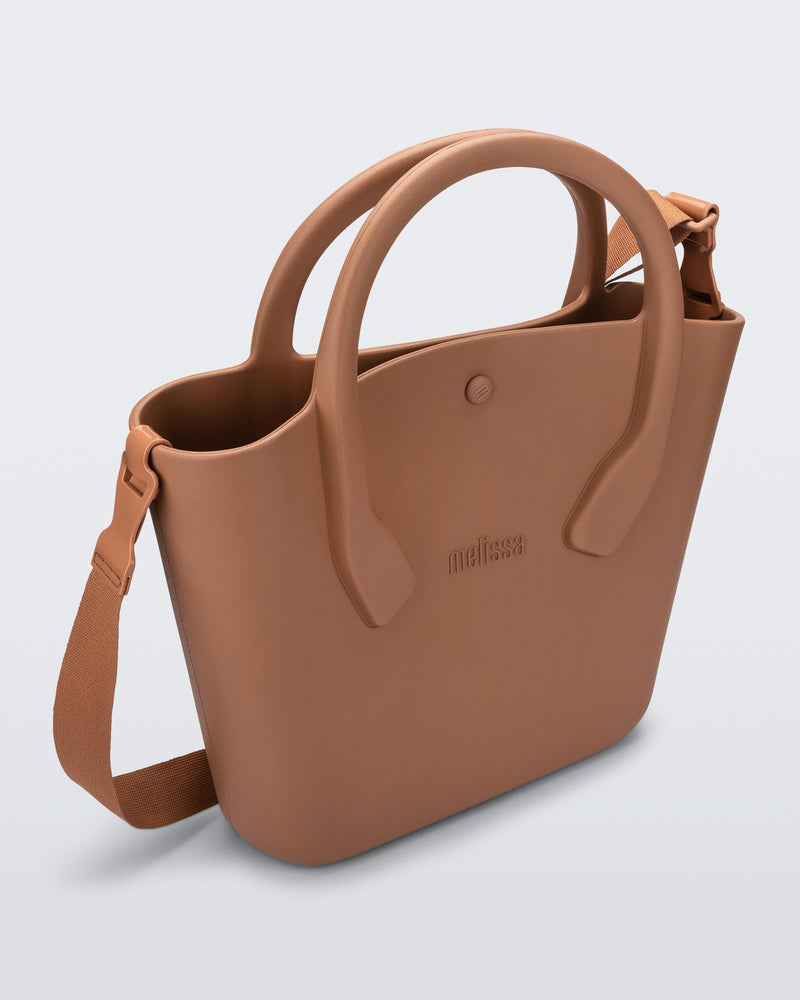 Angled view of a brown Free Big Bag with handles and a strap