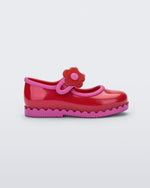 Side view of a red with pink trim Hip Ballerina baby flat with strap with flower