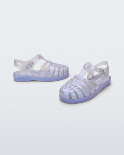 An angled front and side view of a pair of pearly blue Mini Melissa Possession sandals with a fisherman sandal design