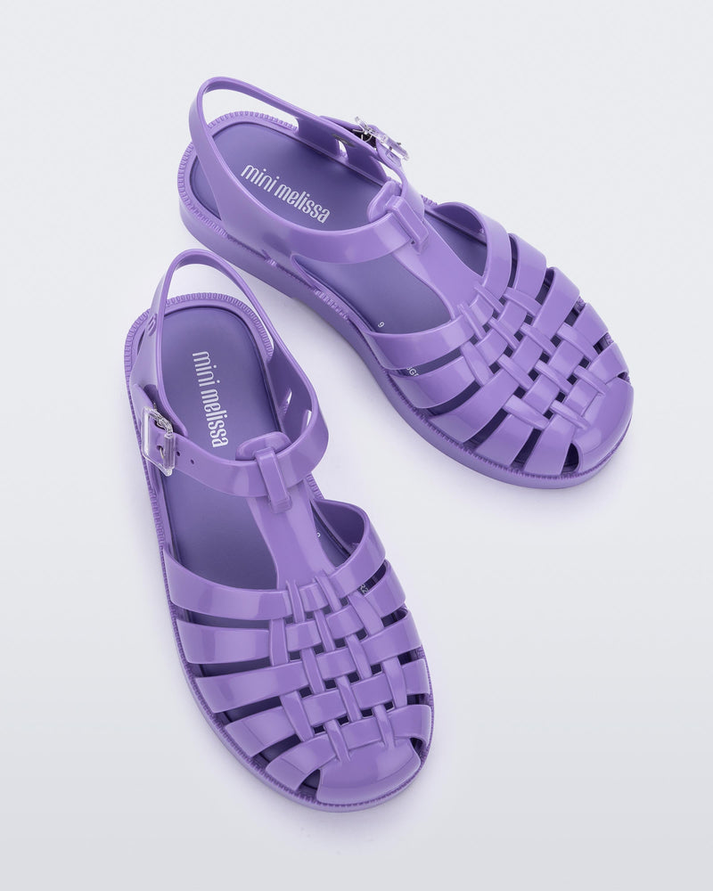 Top view of a pair of lilac Mini Melissa Possession sandals with several straps and a lilac base.