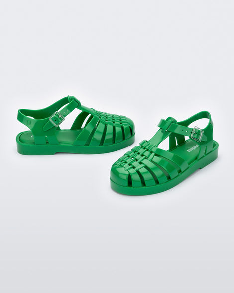 An angled front and side view of a pair of green Mini Melissa Possession sandals with several straps and a green base.