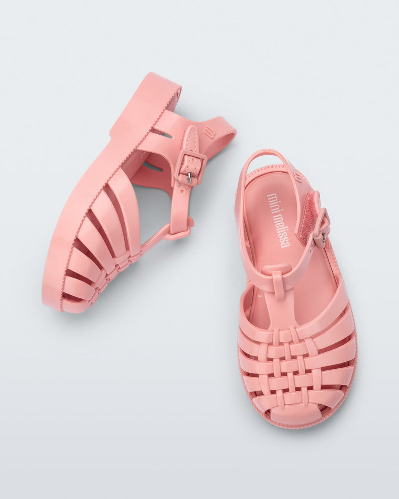 Top and angled view of a pair of light pink baby Possession sandals.