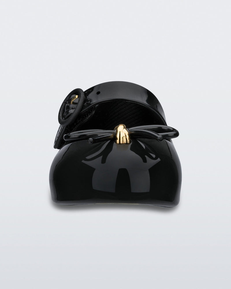 Front view of a black Mini Melissa Sweet Love flat with a top strap and a bow detail on the toe.