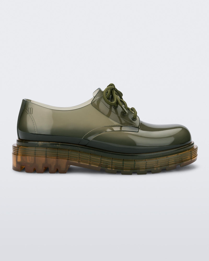 Side view of a pair of clear green / yellow Melissa Bass sneaker, with a transparent green base, green laces and a transparent yellow sole.