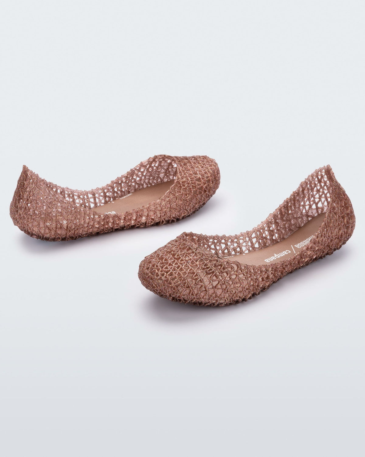 An angled side view of a pair of rose glitter Mini Melissa Campana flats with a woven detail base.