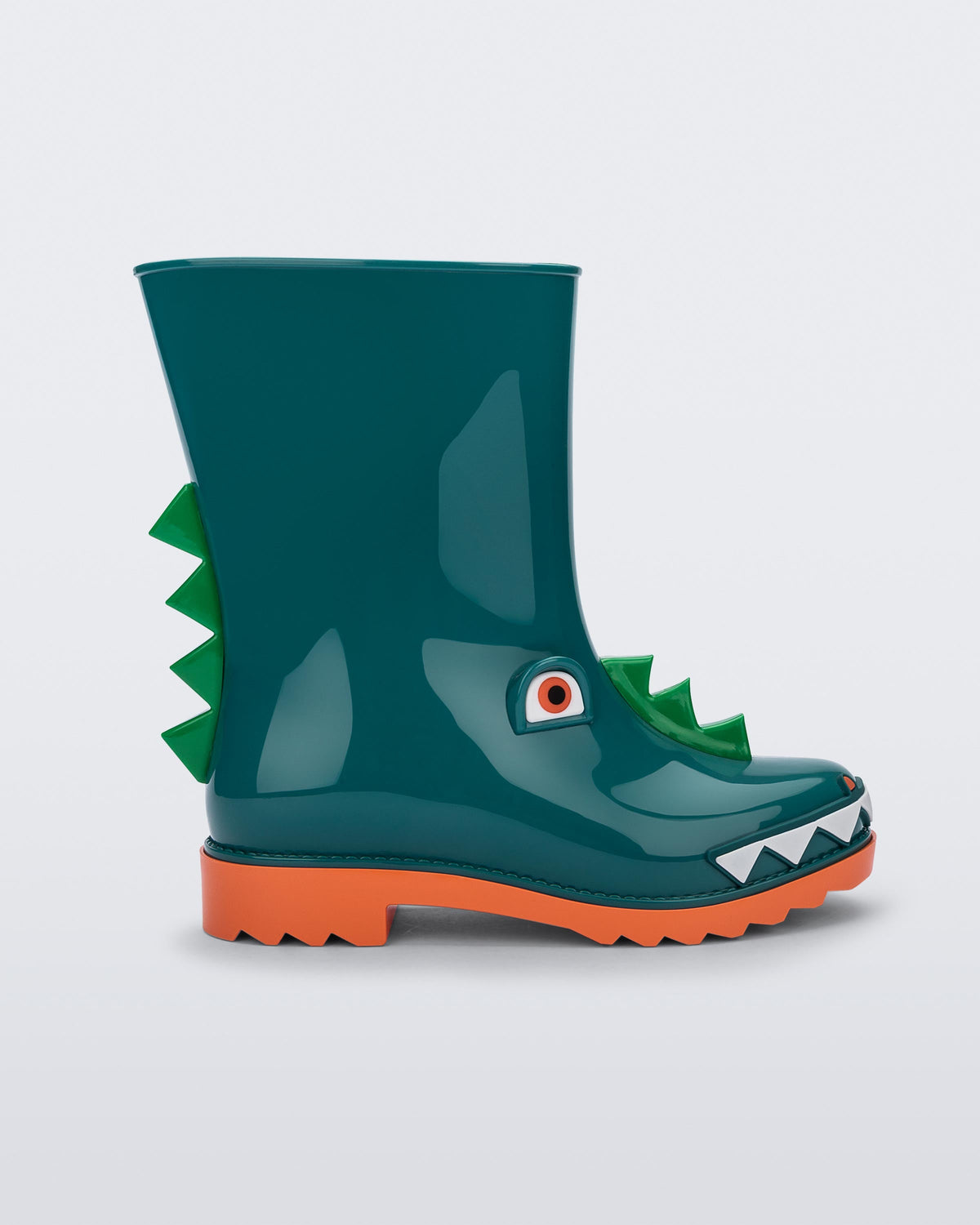 Side view of a orange/green Mini Melissa Rain Boot with a green base, orange sole, light green triangle details, white triangle details in the front and a set of orange eyes which looks like a dinosaurs face,