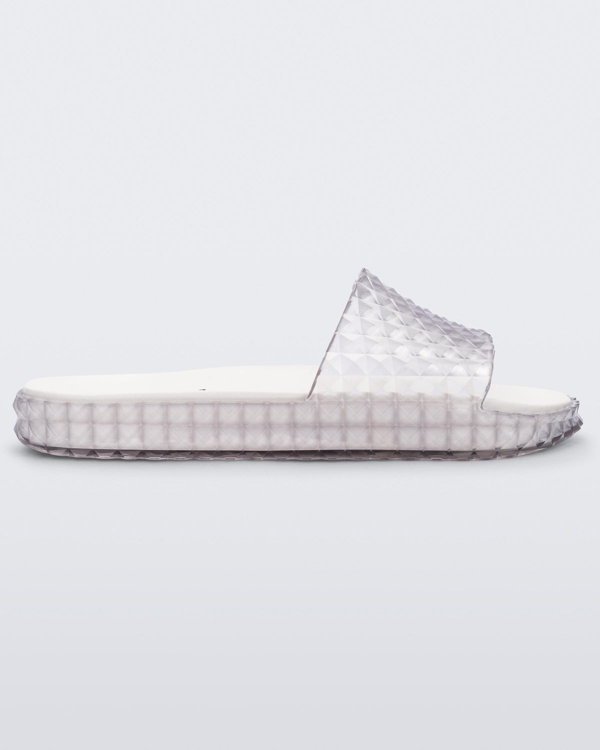 Side view of a clear/white Melissa Court Slide with a checkered pattern texture.