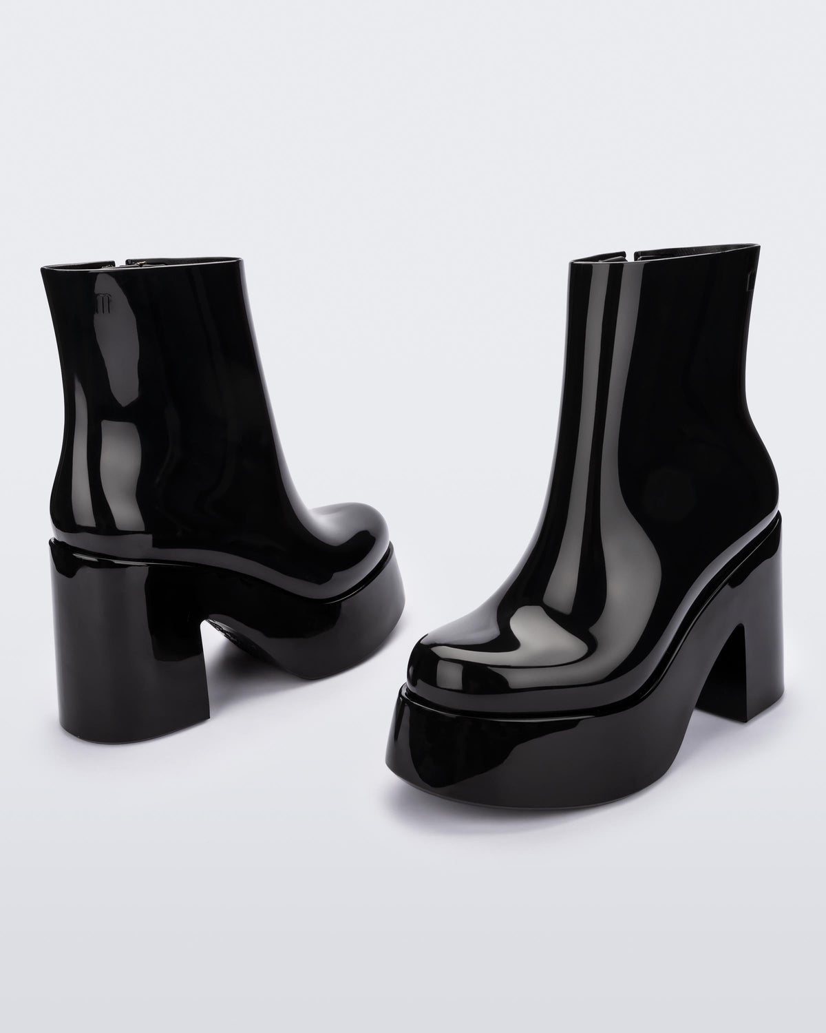 Angled and back view of a pair of black Melissa Nubia platform heel boots.