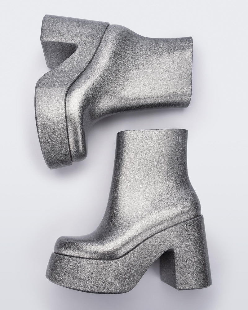 Top view of a pair of silver glitter Melissa Nubia platform heel boots.
