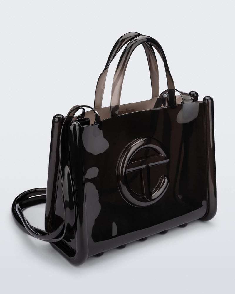 Angled view of a black medium Melissa Jelly Shopper bag + Telfar bag with a handle and straps.