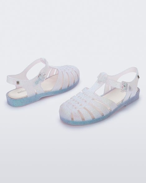 Angled view of a pair of clear glitter Possession sandal.