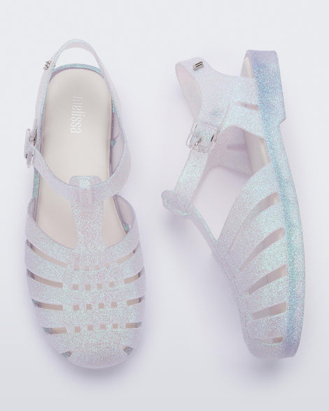 Top and side view of a pair clear glitter Possession sandal.