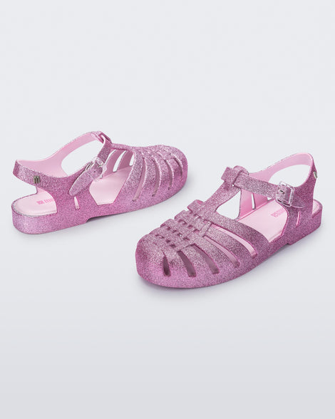 Angled view of a pair of glitter pink Possession sandals.