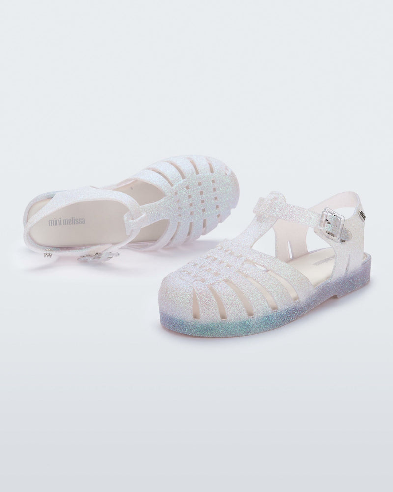 Angled view of a pair of clear glitter kids Possessions.