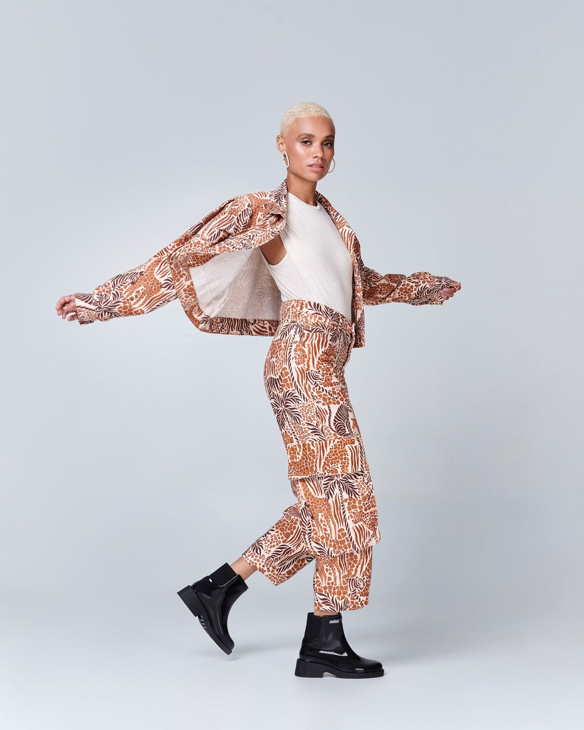 Model in a patterned pant suit wearing a pair of black Chelsea Boots.