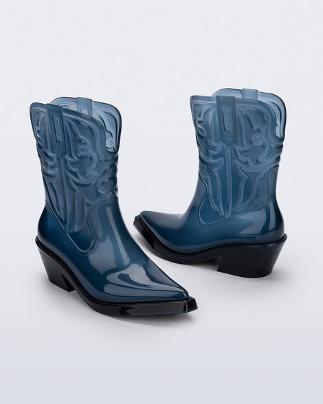 Angled view of a pair of transparent blue Texas boots with pointed toe and black soles.