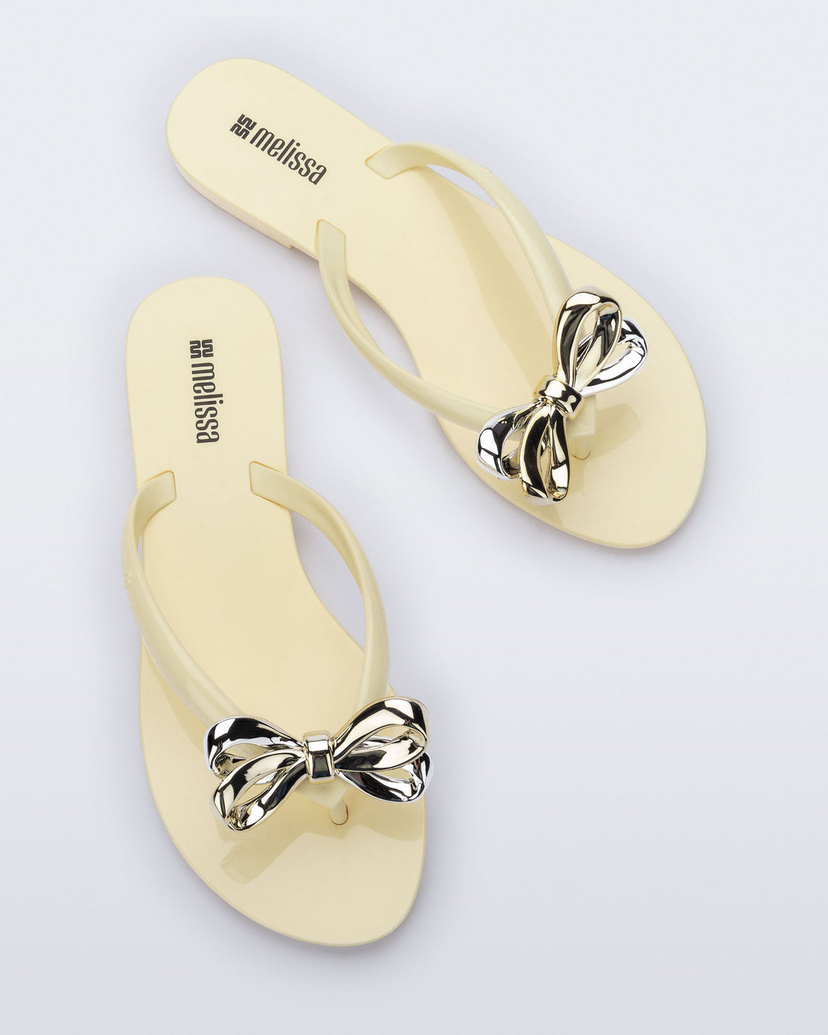 Top view of a pair of Harmonic Eclipse flip flops with bow.