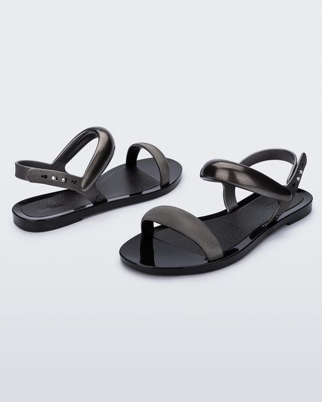 Angled view of a pair of black Eclipse Sandals with silver straps.