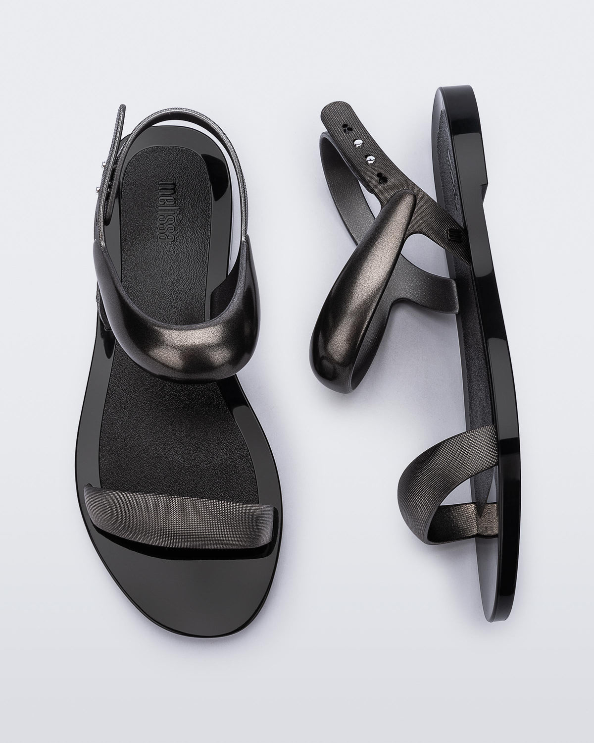Top and side view of a pair of black Eclipse Sandals with silver straps.