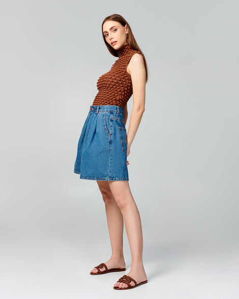 Model in jean shorts wearing a pair of brown M Slides.