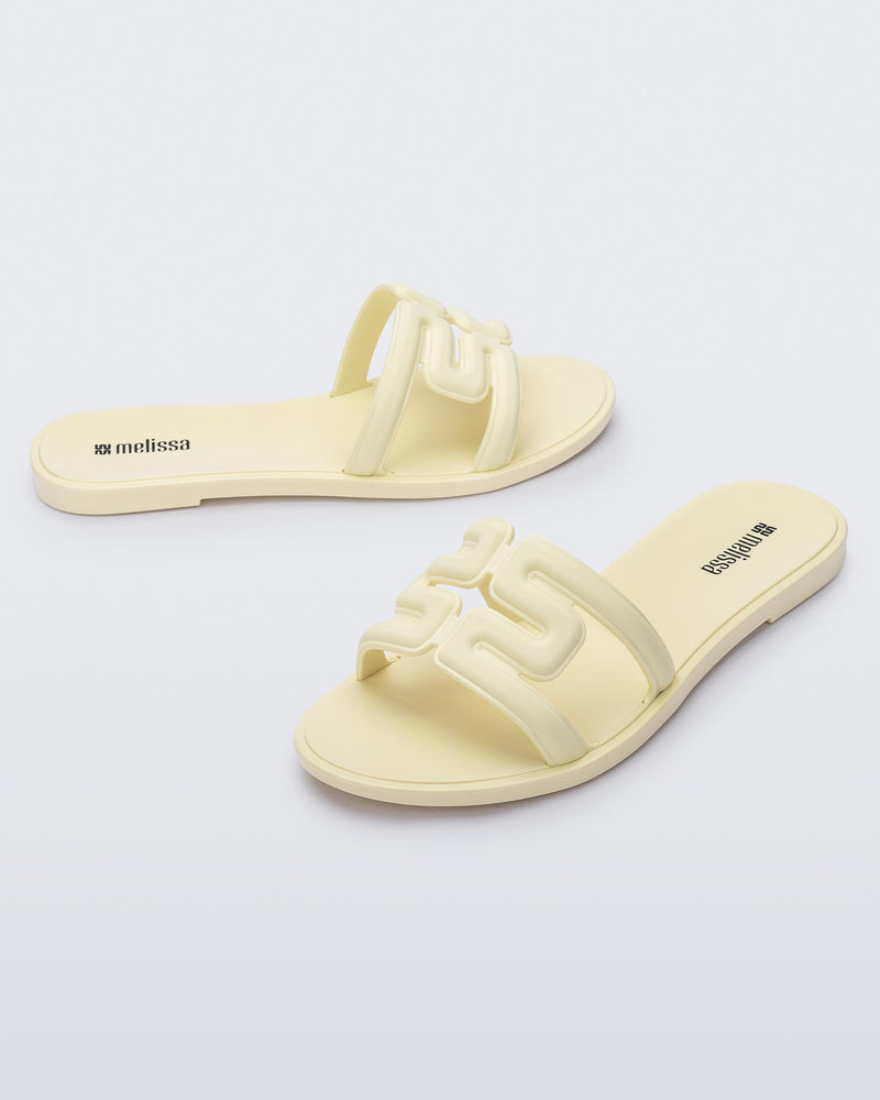 Angled view of a pair of beige M Slides.