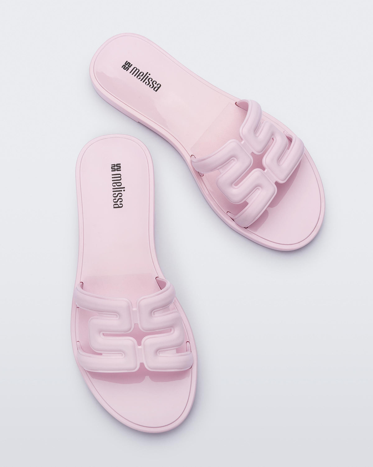Top view of a pair of light pink M Slides.