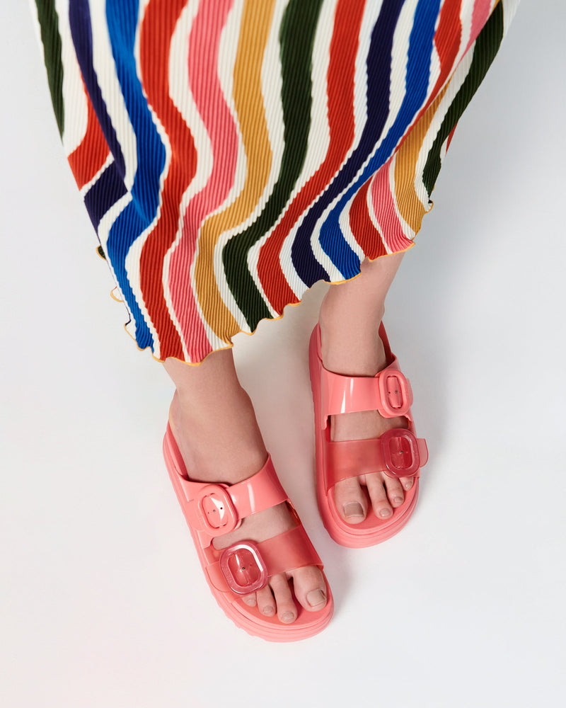 Model's legs wearing a pair of pink Cozy Platform slides.