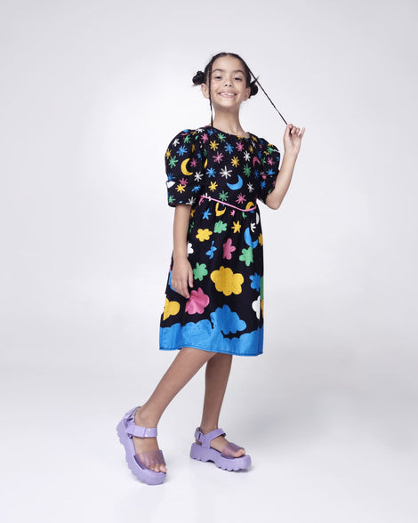 Model posing in a patterned dress wearing a pair of Mini Melissa Kick Off platform sandals in lilac with adjustable velcro ankle straps