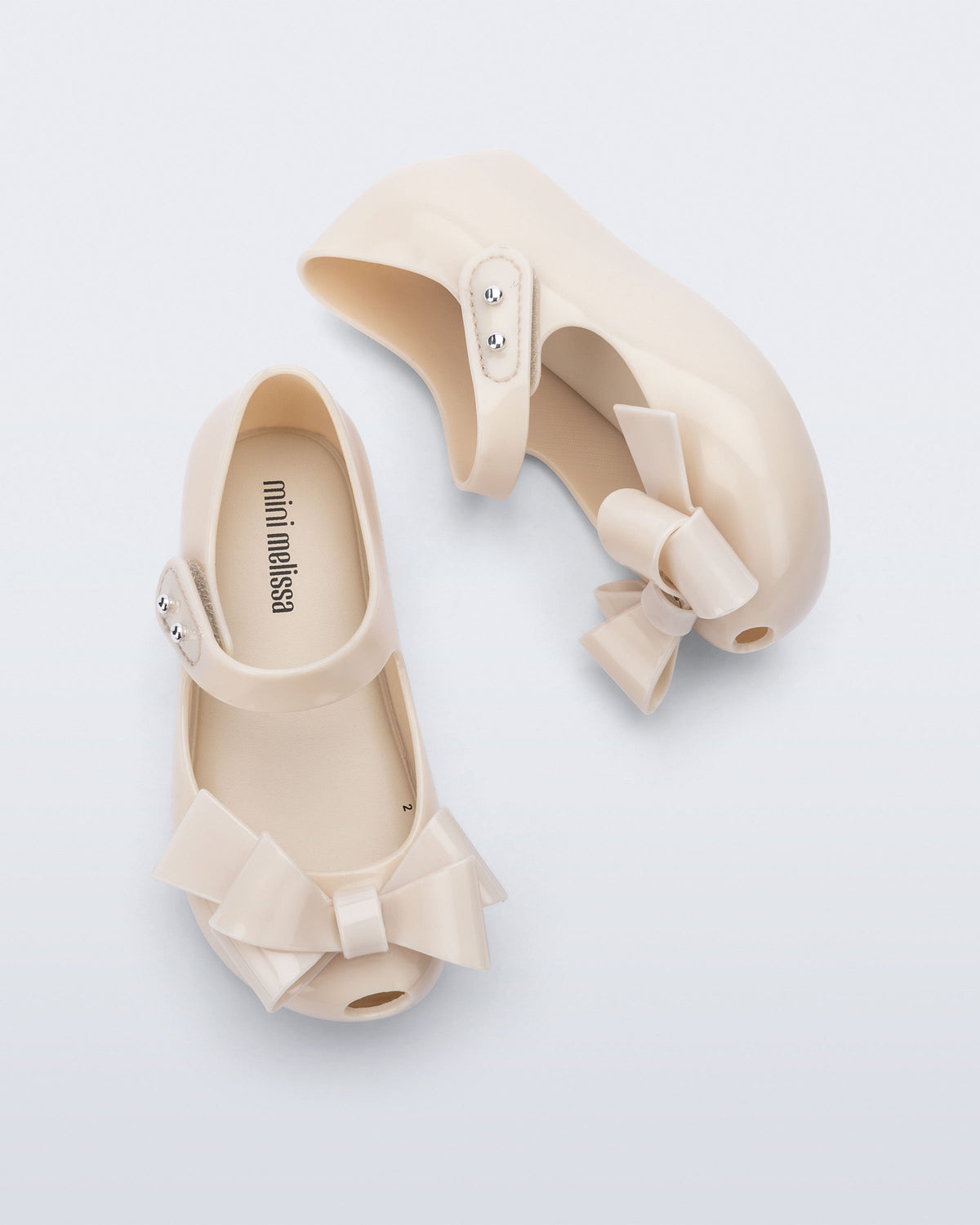 Top and side view of a pair of beige Ultragirl Classy baby ballerina flats with beige bow
