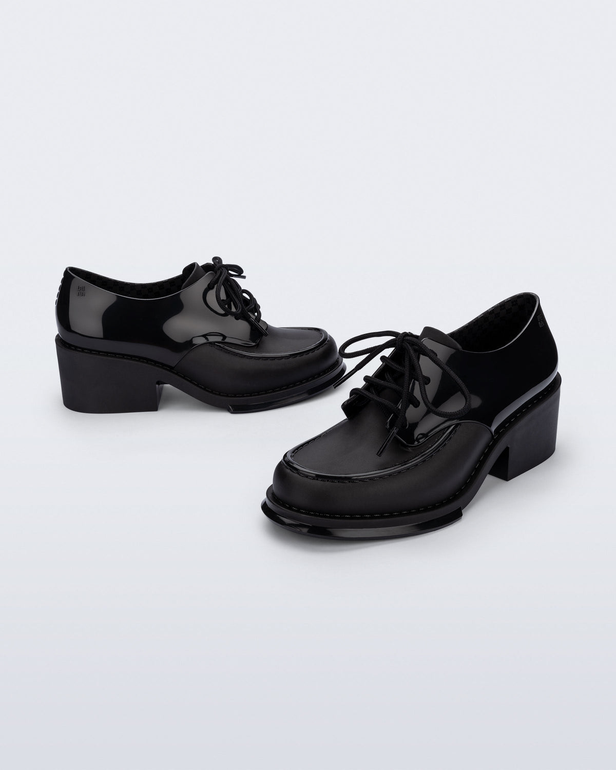 Side and angled view of a pair of black Tailor loafers