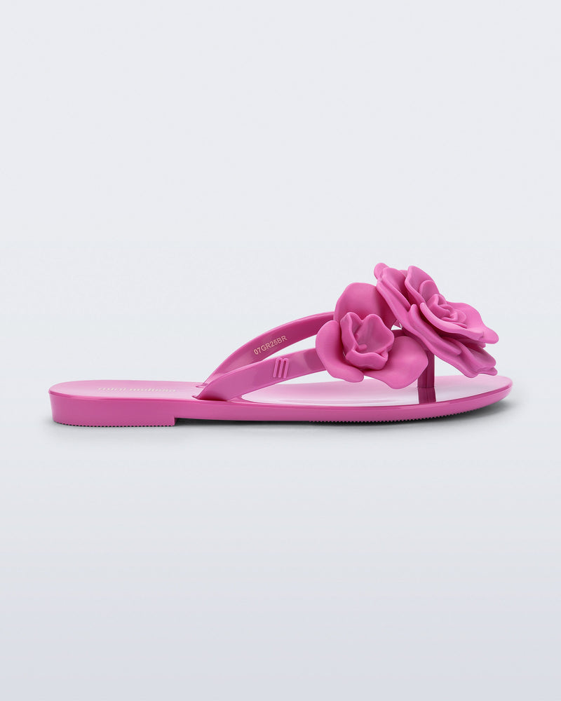 Side view of a pink Harmonic Petals kids flip flop with flowers