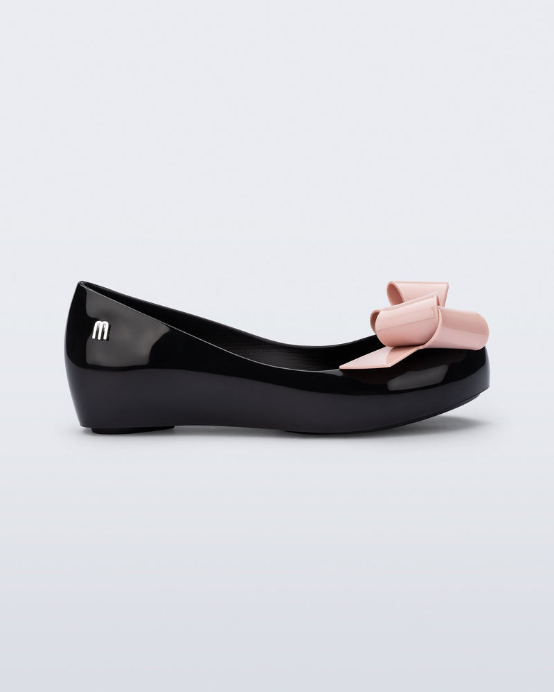 Side view of a black Ultragirl Classy kids ballerina with pink bow.