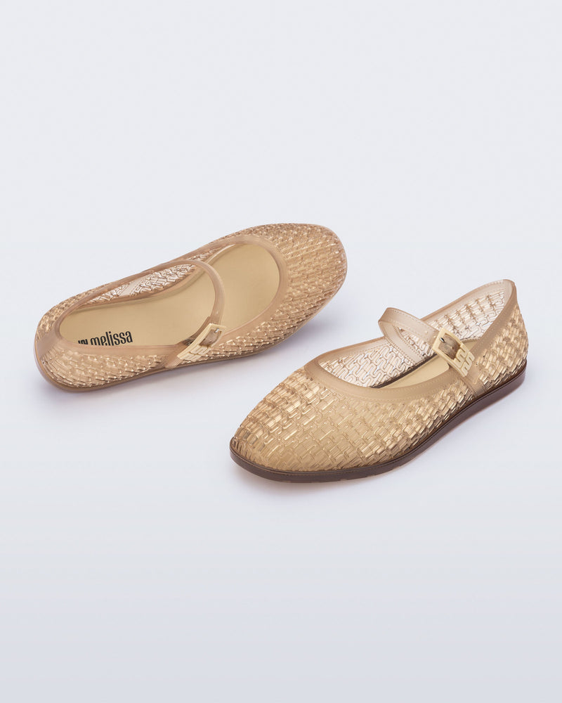 Top and angled view of a pair of clear beige Harper flat with strap