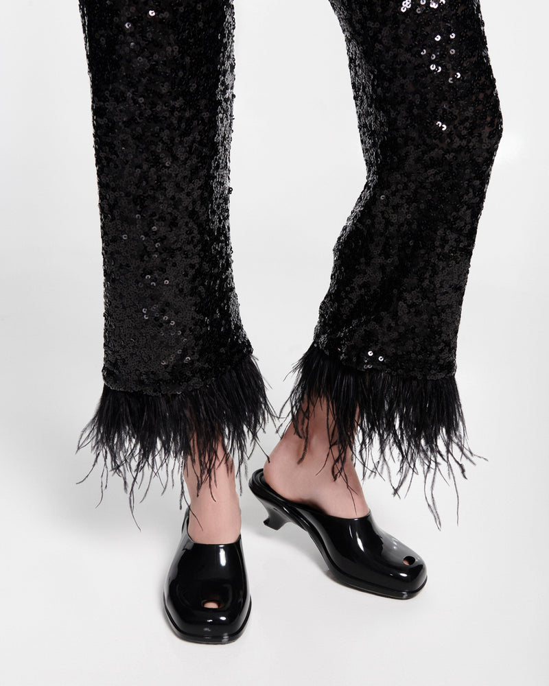 Model's legs in black pants wearing a pair of black Gaia kitten heels with peep toe