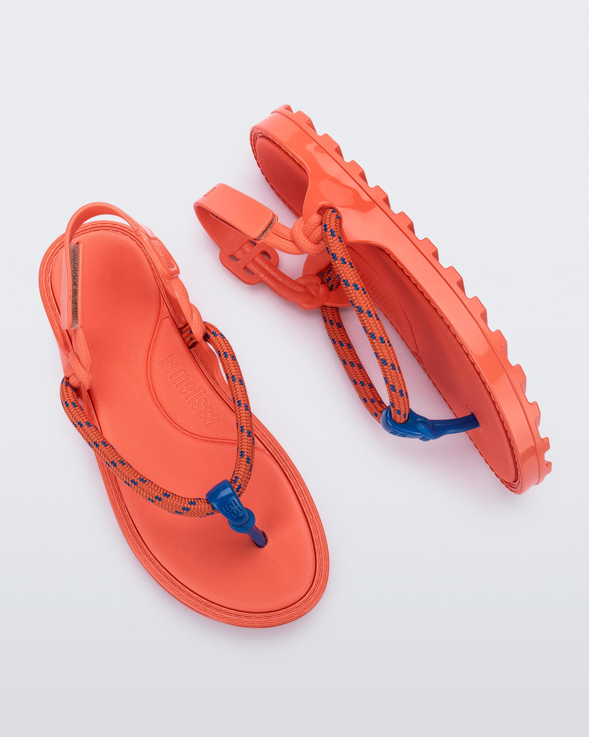 Top and side view of a pair of orange Bond sandals with textile strap and blue toe piece