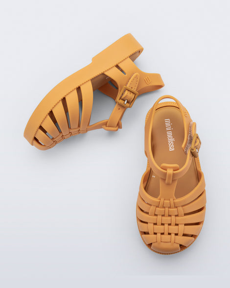 Top and side angled view of a pair of matte caramel Possession baby fisherman sandals.