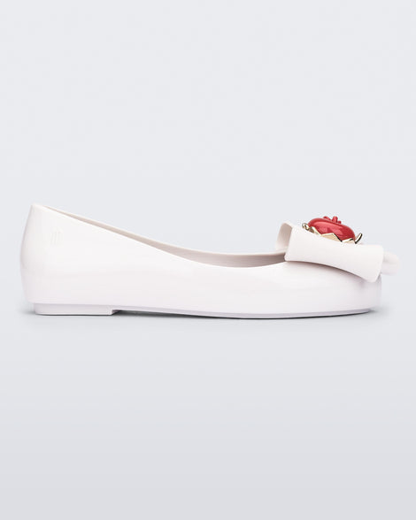 Side view of a white Sweet Love Snow White kids flat with a white bow with red apple center