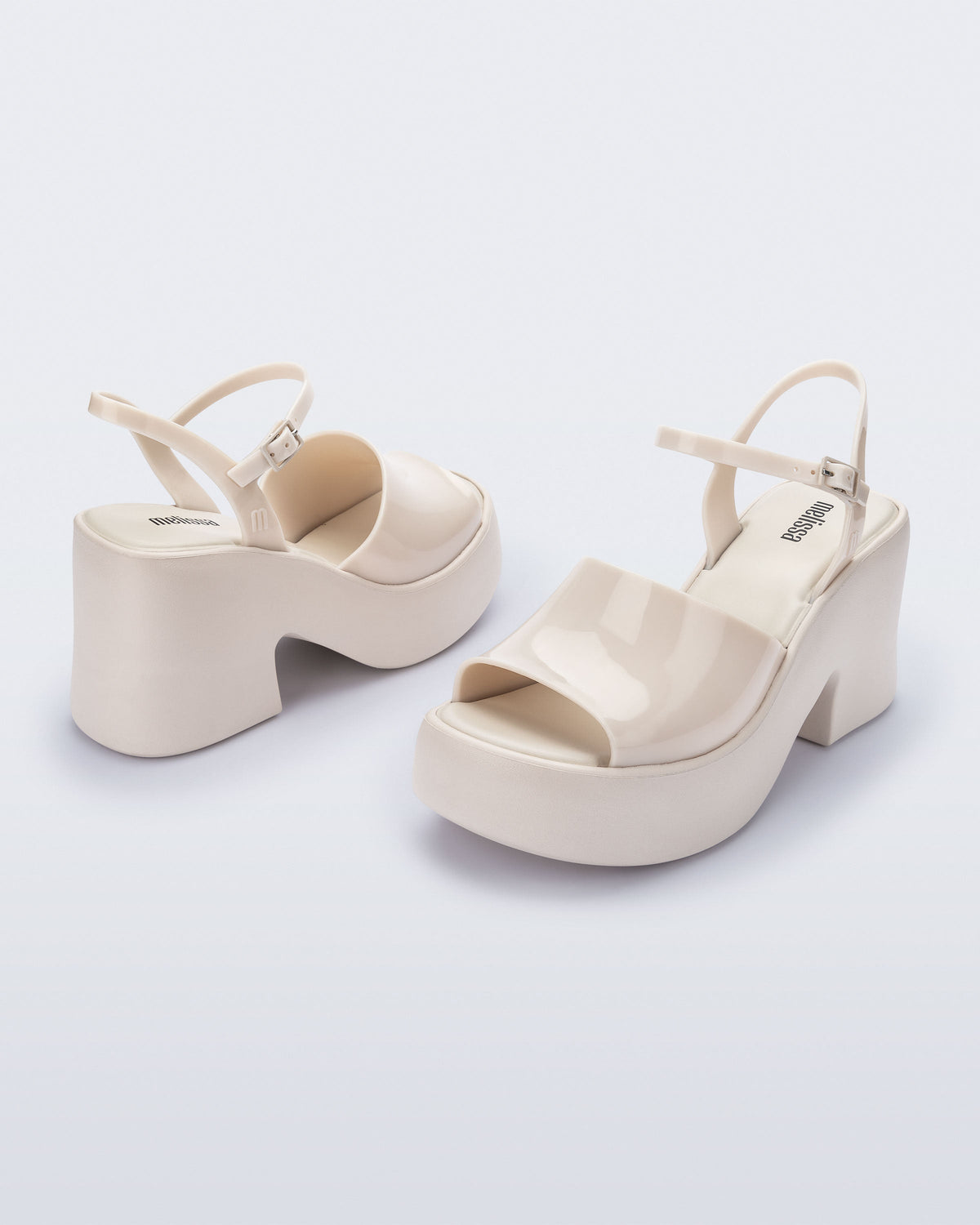 Angled view of a pair of beige Lina platform heels
