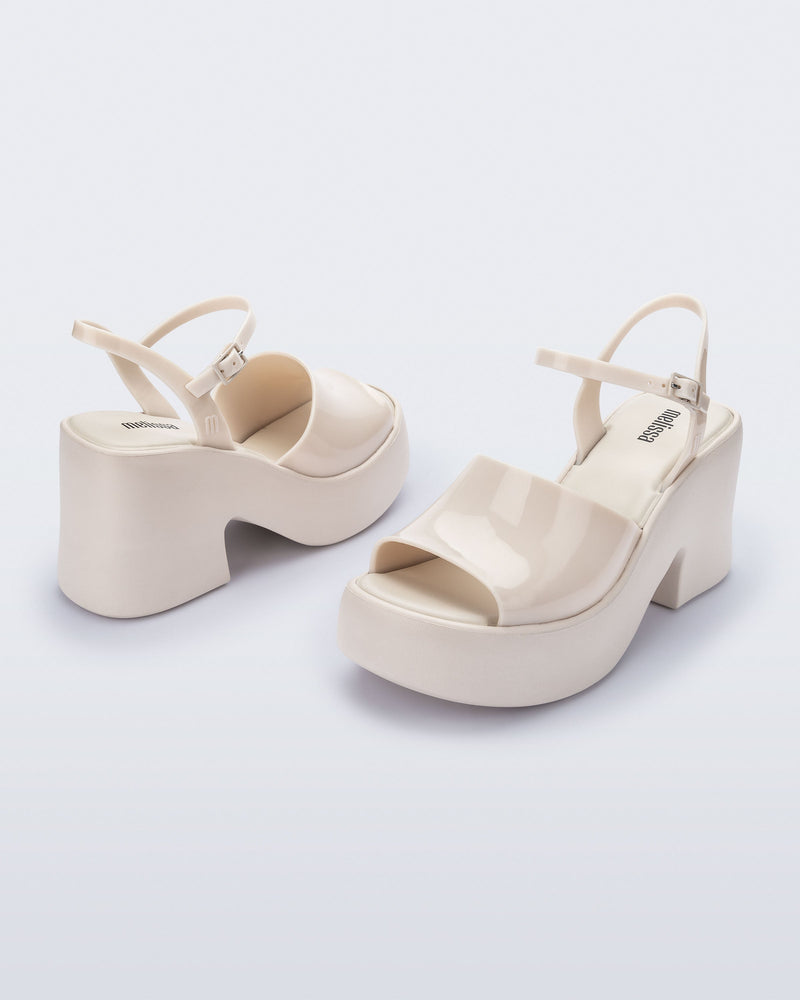 Angled view of a pair of beige Lina platform heels