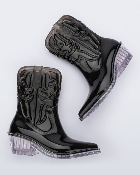 Side view of a pair of black Texas boots with pointed toe and clear sole.