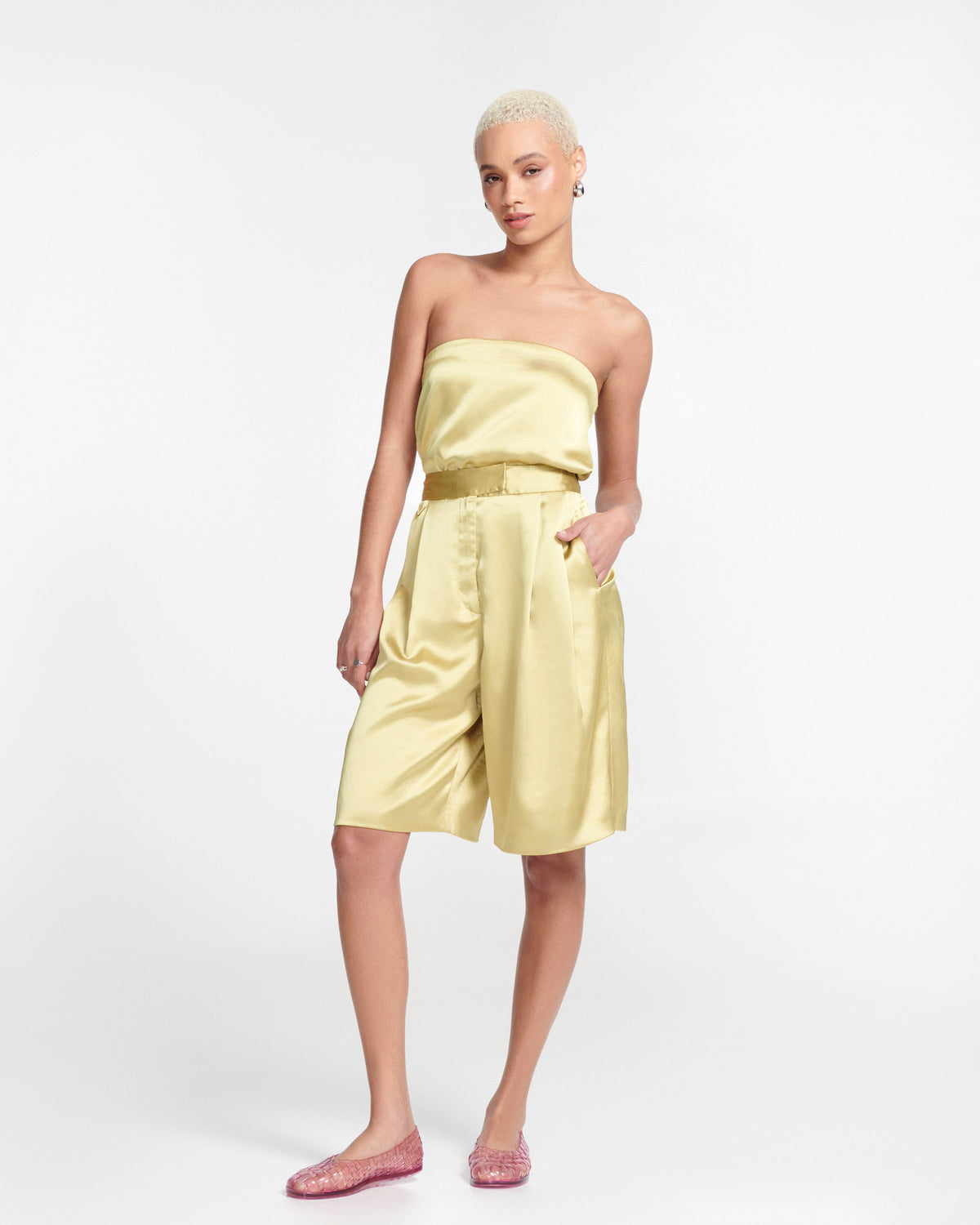Model in gold satin outfit wearing a pair of clear pink Possession Ballerina flats