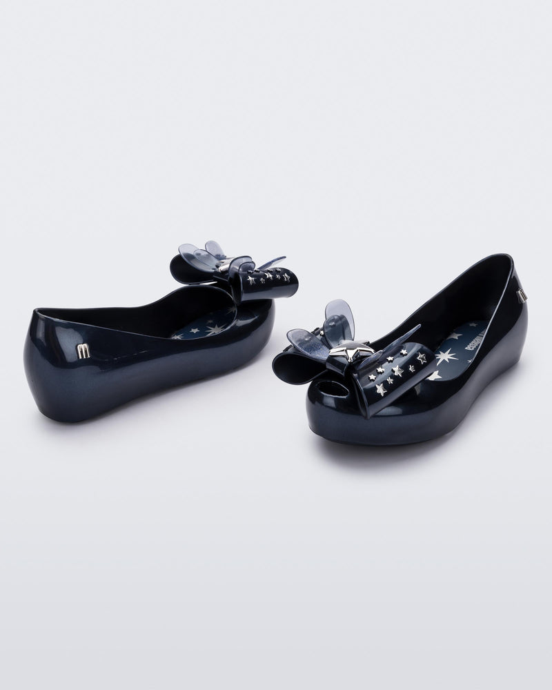 Angled view of a pair of Mini Melissa Ultragirl peeptoe ballet flats in blue with star printed butterfly bow applique.