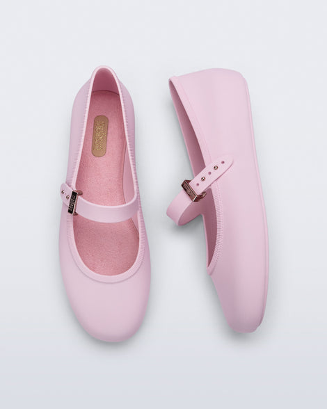 Side and top view of a pair of pink Soft Ballerina flats with top buckle strap